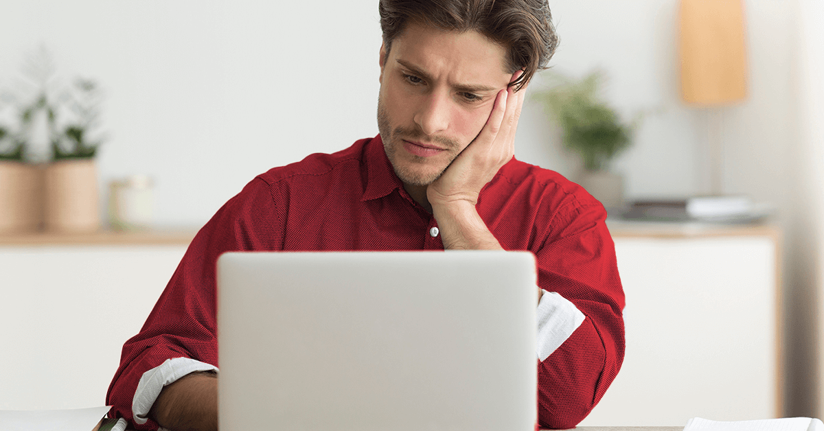 Upset man working in front of a laptop